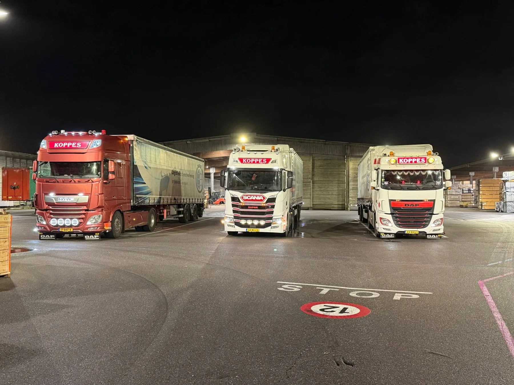 Drie trucks bij nacht op het terrein